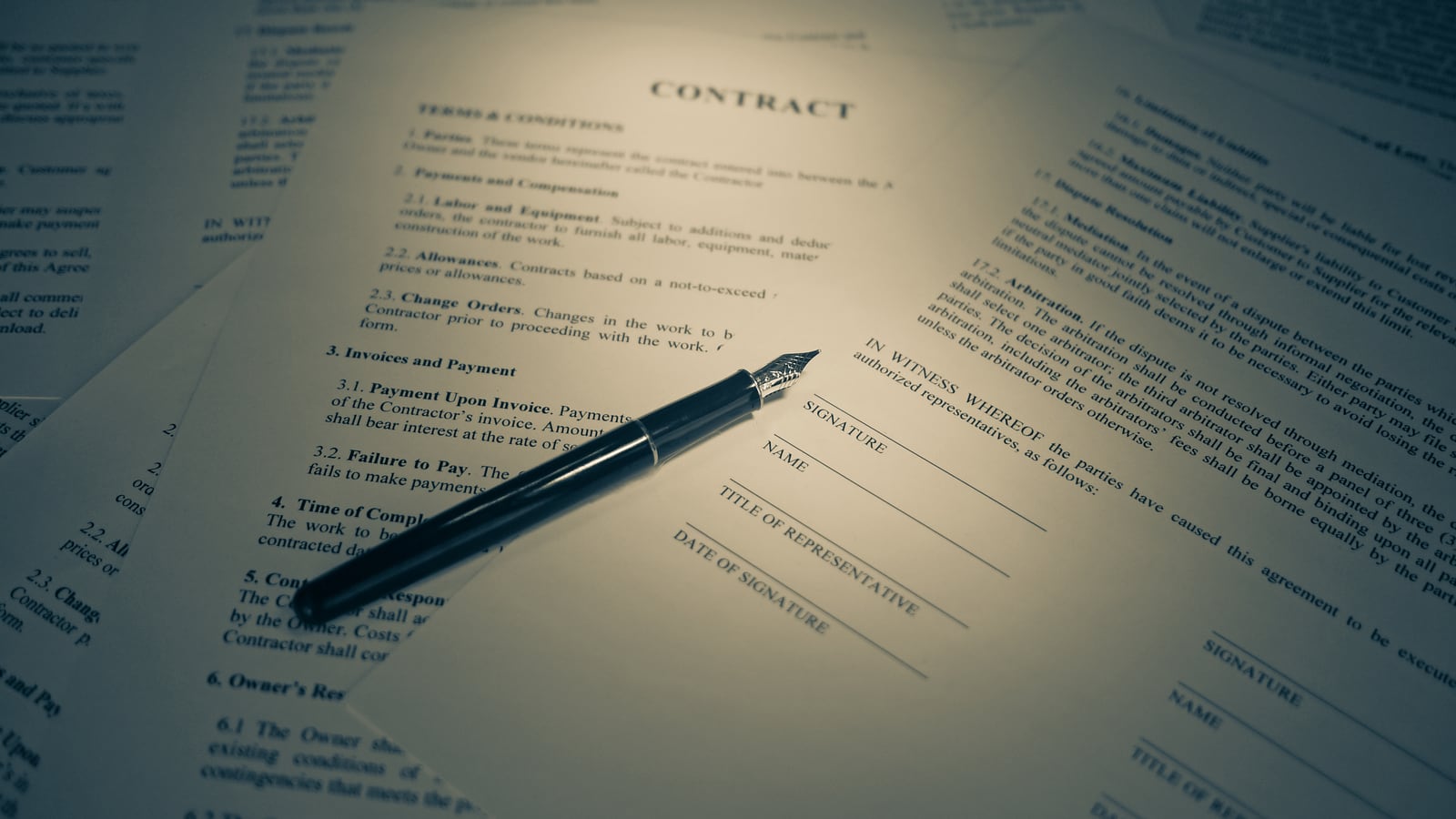 A fountain pen resting on a printed contract