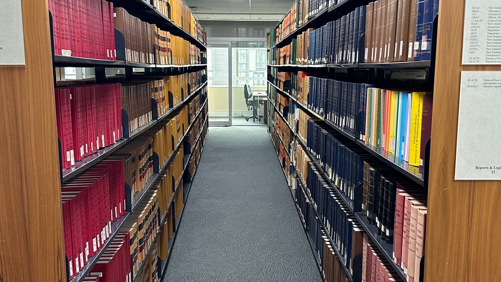 A law library aisle between tall shelves of bound volumes