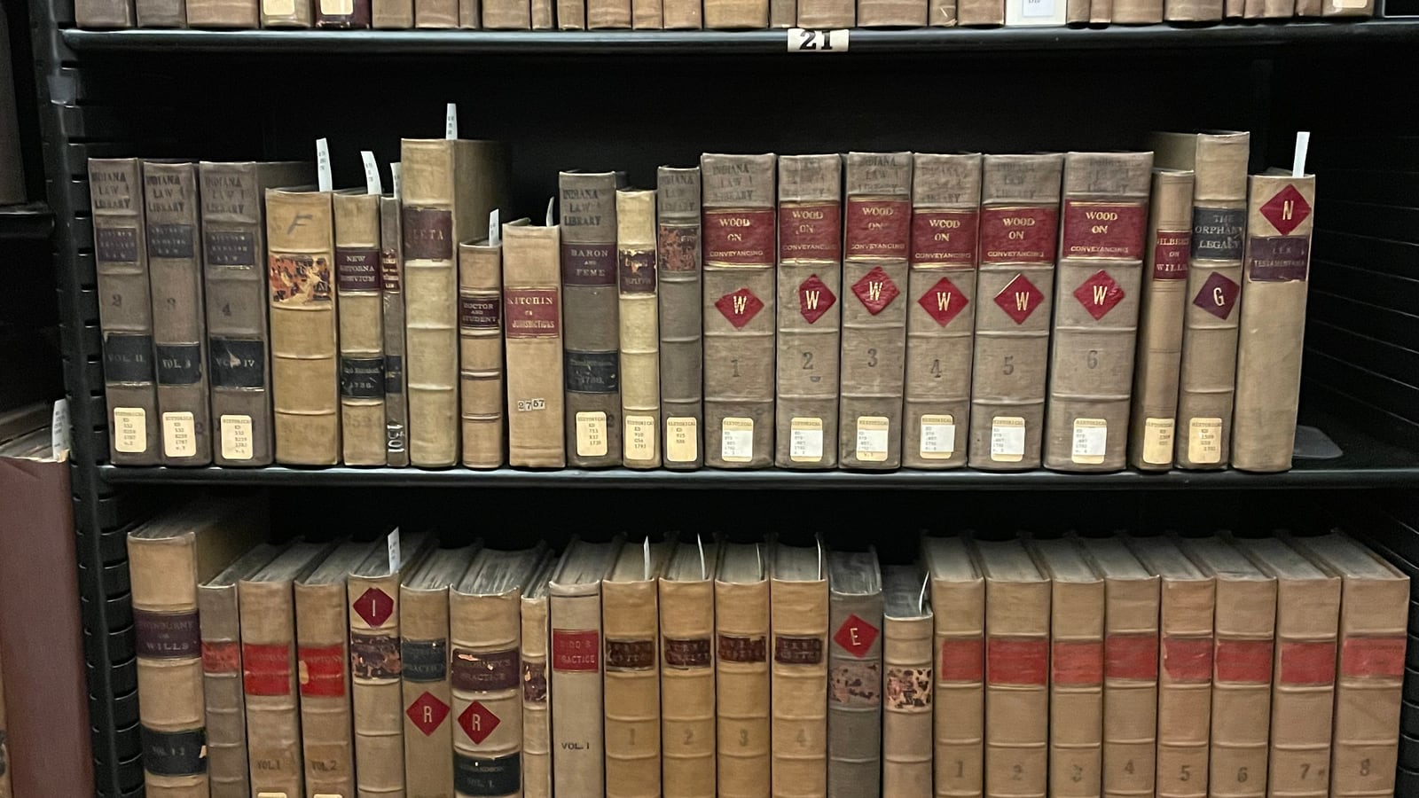 Rows of old bound law reports on a dark shelf