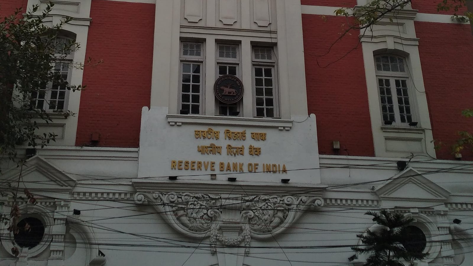 Red-brick facade of the Reserve Bank of India's office in Kolkata, with its emblem above the door